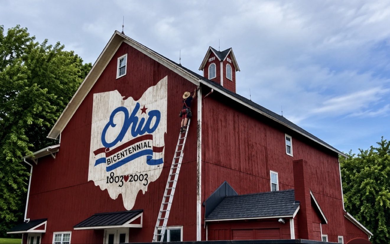 Historic red gambrel barn with lightning rods on its ridge and cupola, protected by WB Lightning Rods